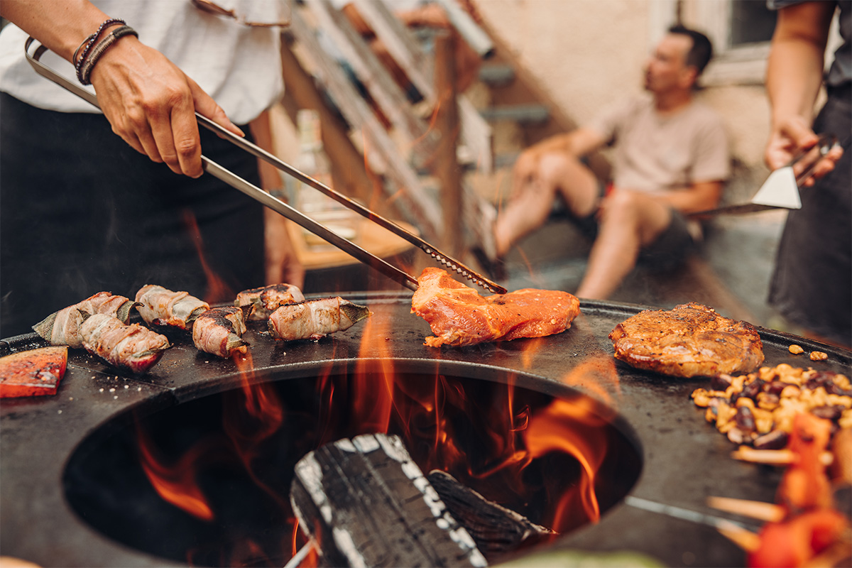 Pince à feu Illustré est une personne en train de cuisiner de la nourriture sur un grill, avec les pinces de barbecue.