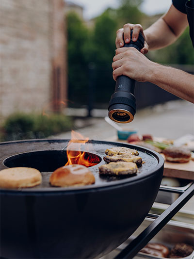 Cette image montre un homme en train de cuisiner de la nourriture sur un grill.