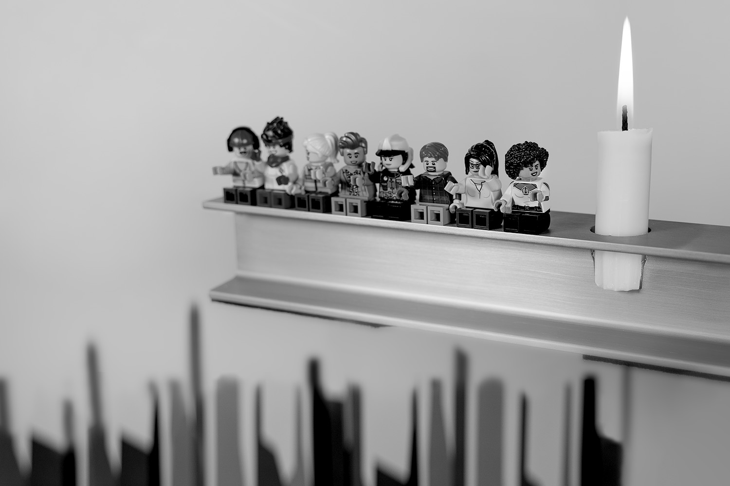 Une bougie et des Lego sur une étagère.