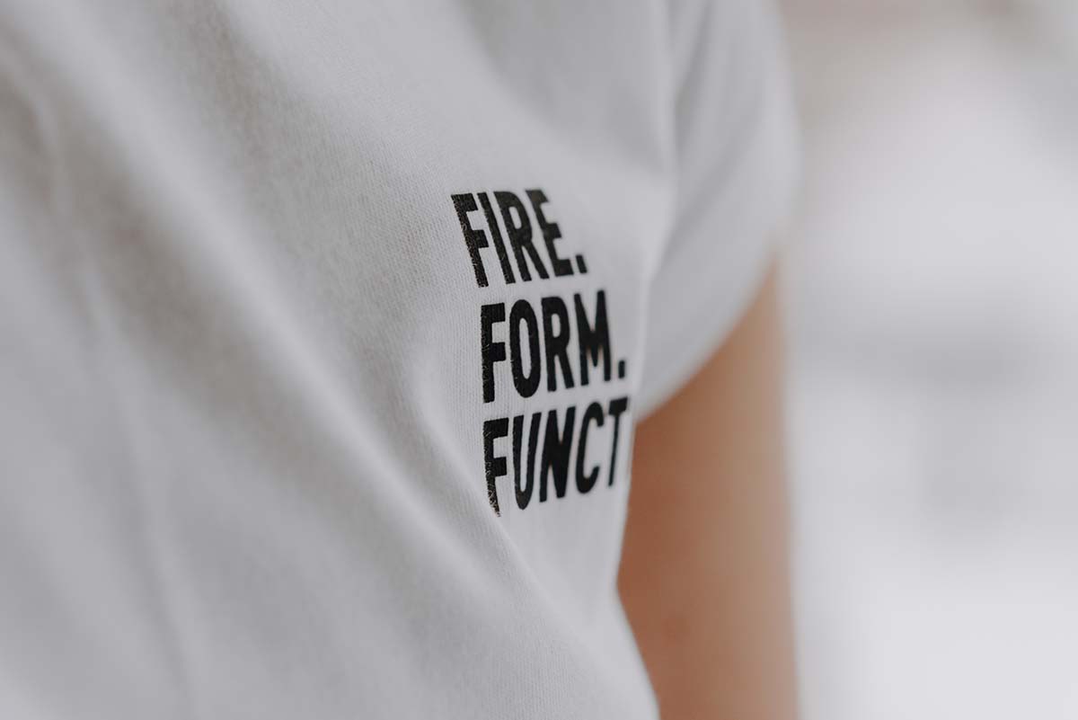 Une femme porte un t-shirt blanc avec les mots feu, amusement.