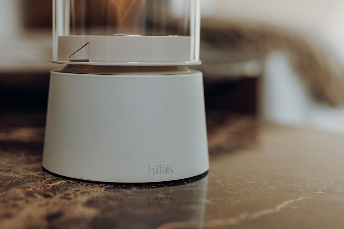 SPIN air 900 Tischfeuer creme SPIN air 1200 creme steht auf einem braunen Tisch ein Foto nur der der Base im Detail