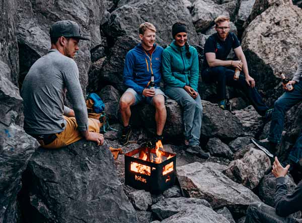 Bouldern bei Feuerschein Ein Bild zeigt eine Gruppe von Menschen, die um ein Lagerfeuer sitzen, mit dem BEER BOX Feuerkorb.