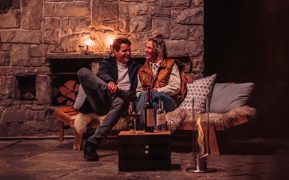 An image showing a couple sitting in front of a Fireplace, with the Atmospheric image Christmas for Console.
