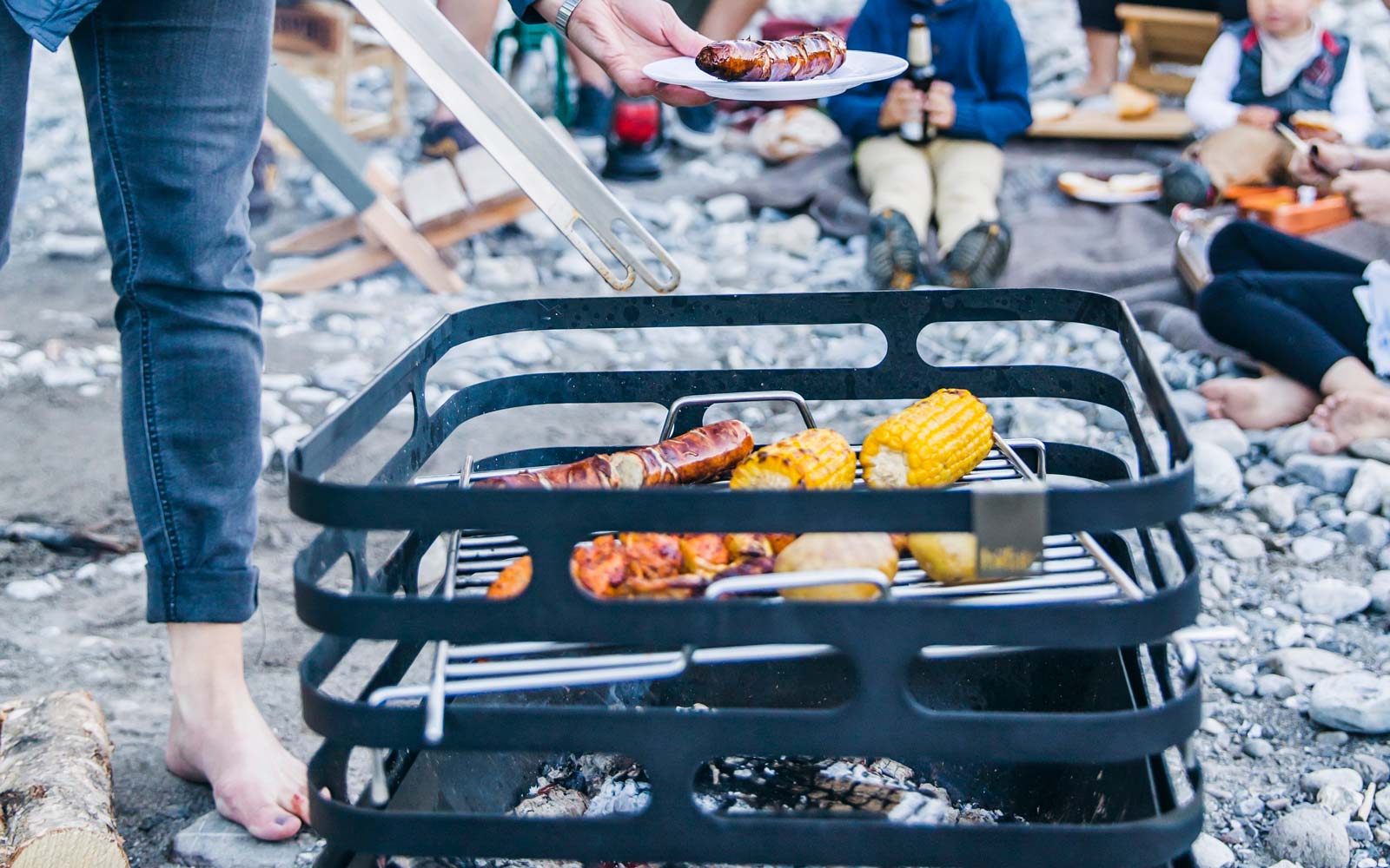 Scène montrant une personne en train de Griller de la nourriture sur un barbecue, où le CUBE Bbq Set se distingue par son élégance pratique.