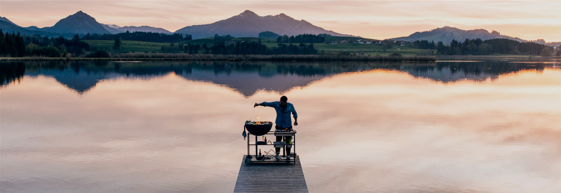 a man standing on a dock with a fishing rod.