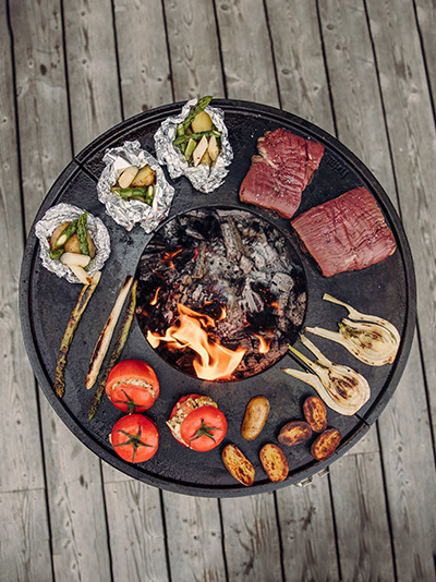 Illustré est un grill avec de la viande et des légumes dessus, avec la CUBE Plancha.