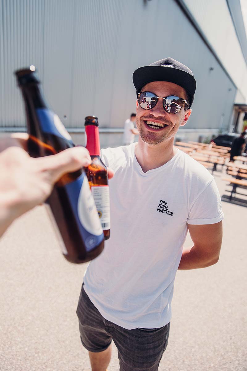 SHIRT hommes blanc M Un homme tenant une bouteille de bière et souriant.