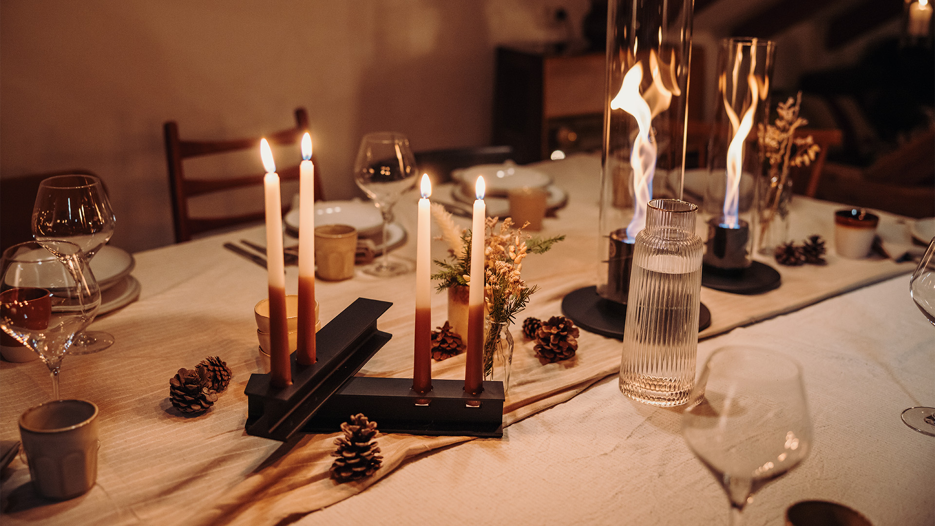 A depiction of a dinner table with candles and candleholders, featuring the 00803 Henry Metal II black as a central and purposeful element.