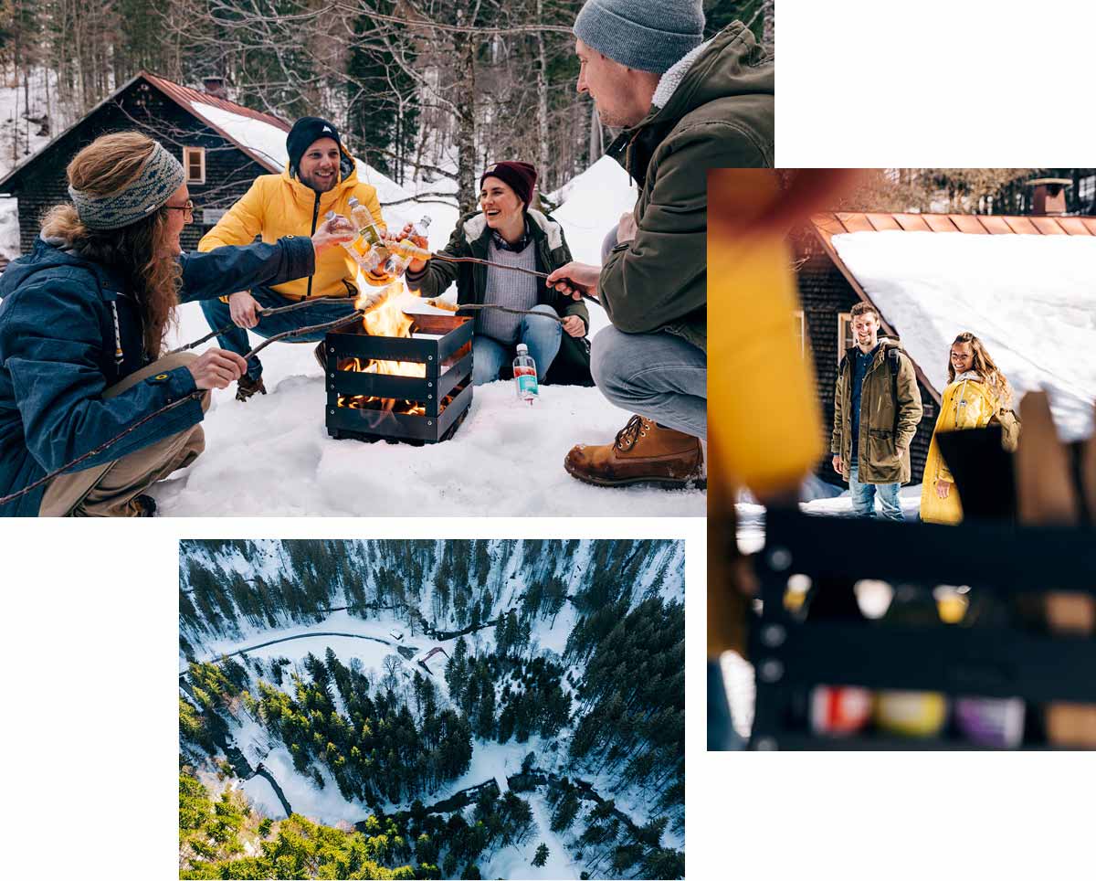 a group of people sitting around a fire in the snow