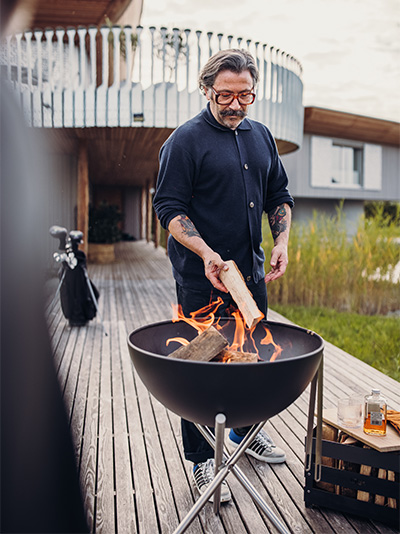 Un homme cuisine sur un grill, avec le bol BOWL Fire BOWL.