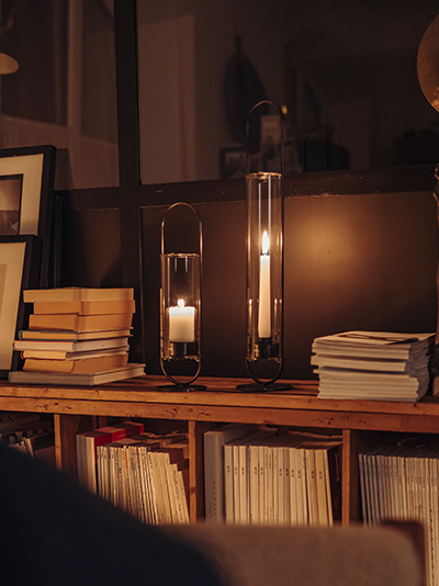 Szene zeigt ein dunkles Zimmer am Abend, nur beleuchtet vom Licht der OVAL Candle, die durch ihre praktische Eleganz hervorsticht.
