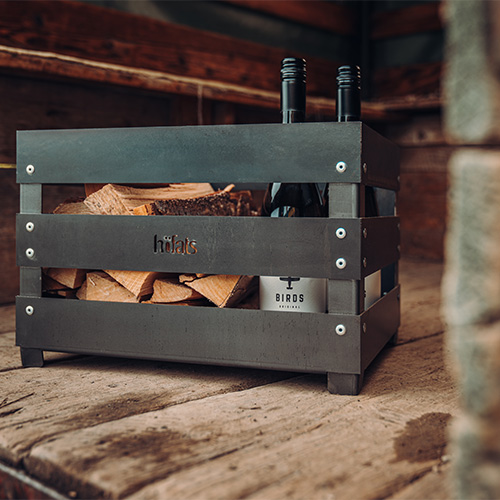 Une image montrant une table en bois, avec le brasero logo CRATE.