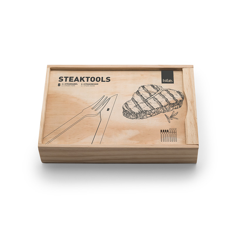 Couverts à steak Une vue d'une boîte en bois avec un dessin d'un steak, avec les outils Steaktools.