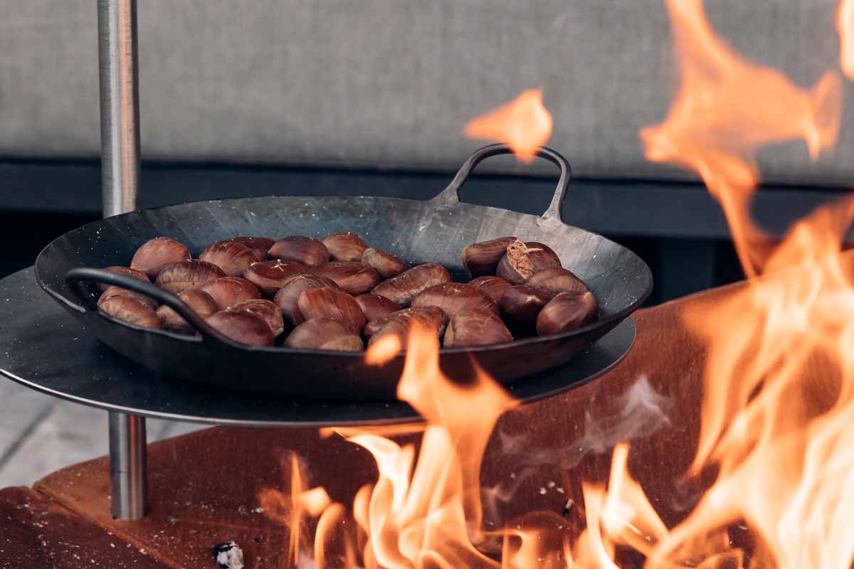 TRIPLE Pole 40 Scene showing a pan of sausages on a fire, where the Triple pole 40 stands out for its practical elegance.