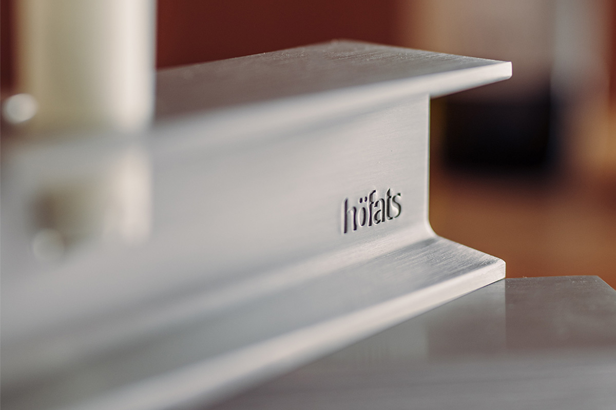 La photo présente un gros plan d'une table blanche avec une bougie, avec le bougeoir HENRY METAL II en argent.