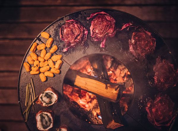 Cette image montre un grill avec de la viande et des légumes dessus, avec le BOWL Fire BOWL.