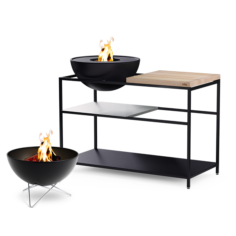 FIRE KITCHEN avec BOWL 57 Set Plancha Grille basse Une vue d'un brasero et d'un BOWL sur une table, avec le FIRE KITCHEN avec BOWL 57 Plancha BBQ Set incl. roues.