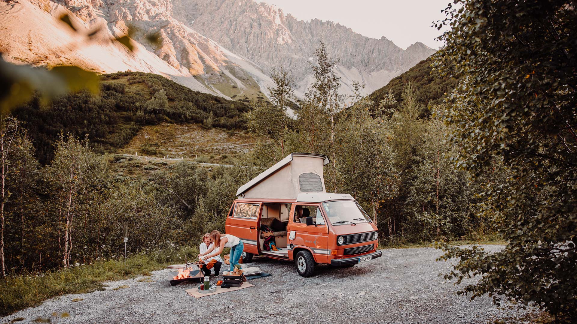 Sur l'image, on voit une camionnette garée sur un chemin de gravier avec une personne assise à l'arrière.
