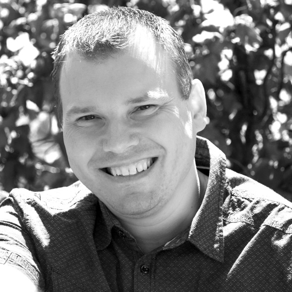 Un homme souriant assis dans un parc.