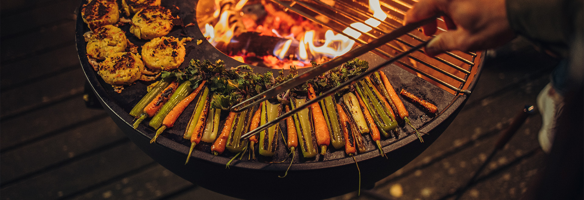 Die Bowl 70 wird gezeigt, während eine Person Essen auf einem Grill zubereitet, was ein stilvolles und zugängliches Bild ergibt.