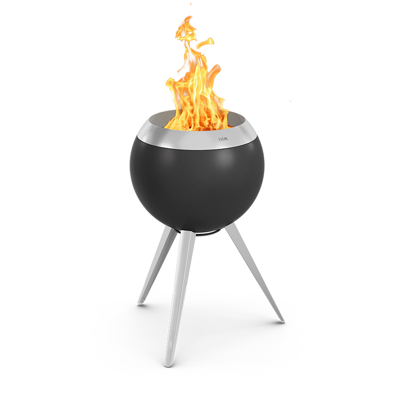 Ein schwarzer Feuergrube mit einer Flamme oben drauf, wobei das 00963 Moon 45 Plancha BBQ Set eine funktionale und elegante Note zur Szene hinzufügt.