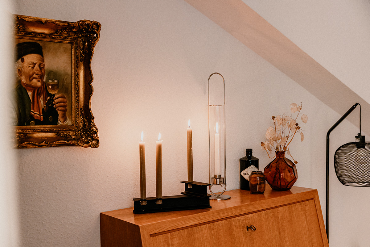 OVAL CANDLE 55 Candleholder silver A picture of a man on a wall, enriched by the presence of the 00271 Oval Candle 55, which merges design with utility.