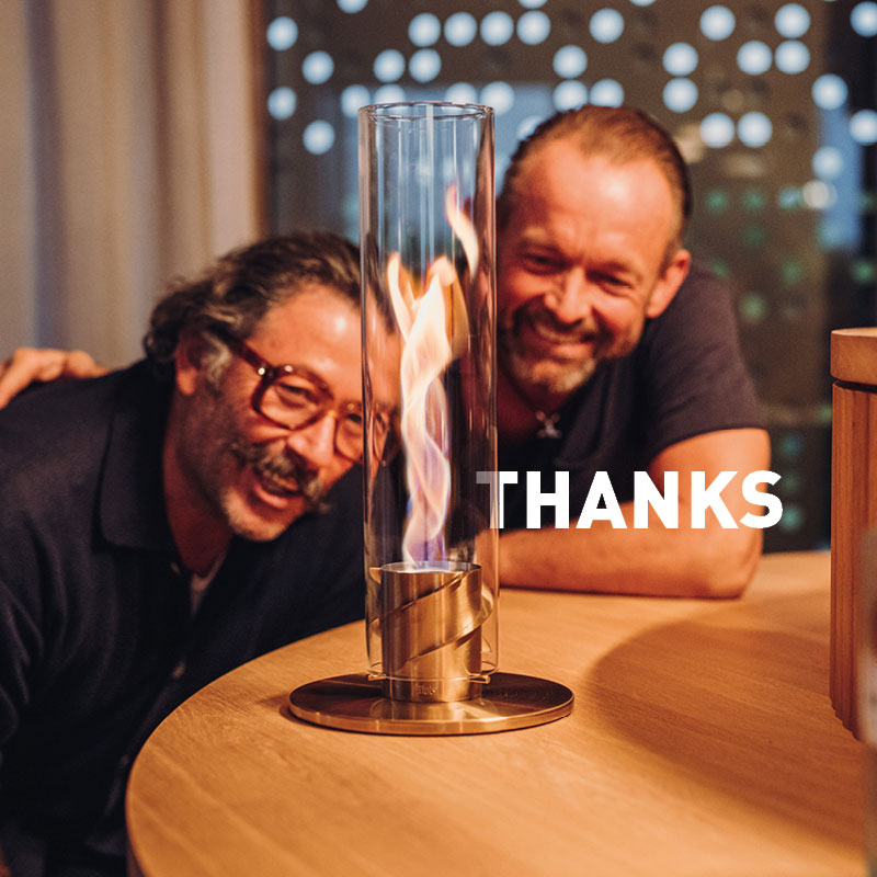 Découvrez deux hommes assis à une table avec un SPINner devant eux et le mot "merci".