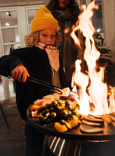 Scène montrant une femme et un enfant en train de Griller sur une MOON, où la MOON Plancha se distingue par son élégance pratique.