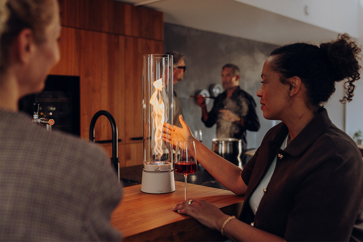Zwei Frauen schauen in die Flamme von SPIN air sand.