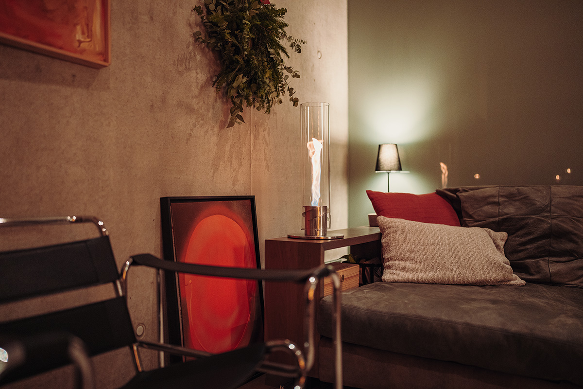 A depiction of a living room with a couch and a table, featuring the 00695 Spin 1200 Tablefire silver as a central and purposeful element.