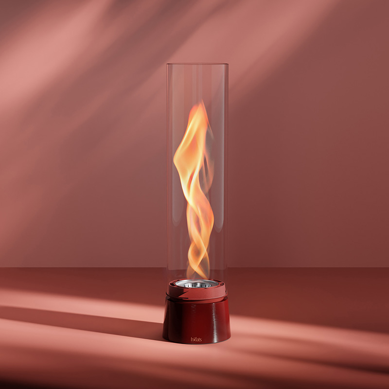 A flame in a glass cylinder with a red base, with the 00814 Spin Air 1200 Tablefire Emaille red adding a functional and elegant touch to the scene.