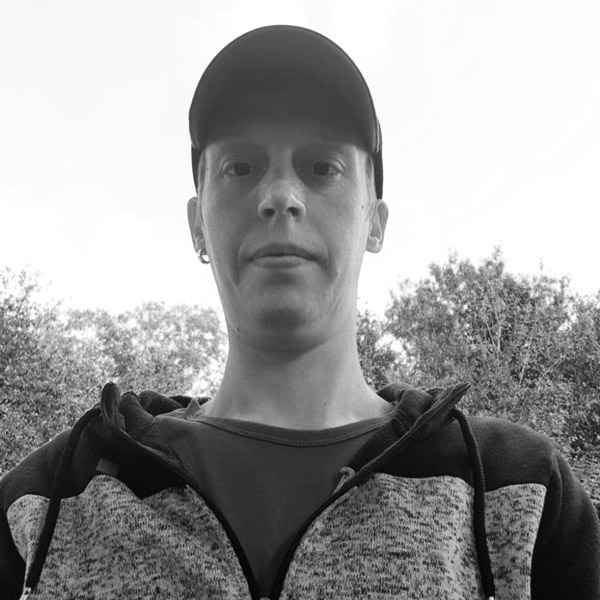 Un homme en casquette de baseball et pull.