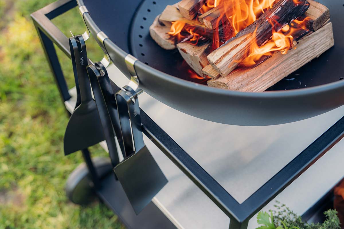 Spatula black A depiction of a large metal fire pit with a firewood burning in it, featuring the 00878 Bbq Tool Set black as a central and purposeful element.