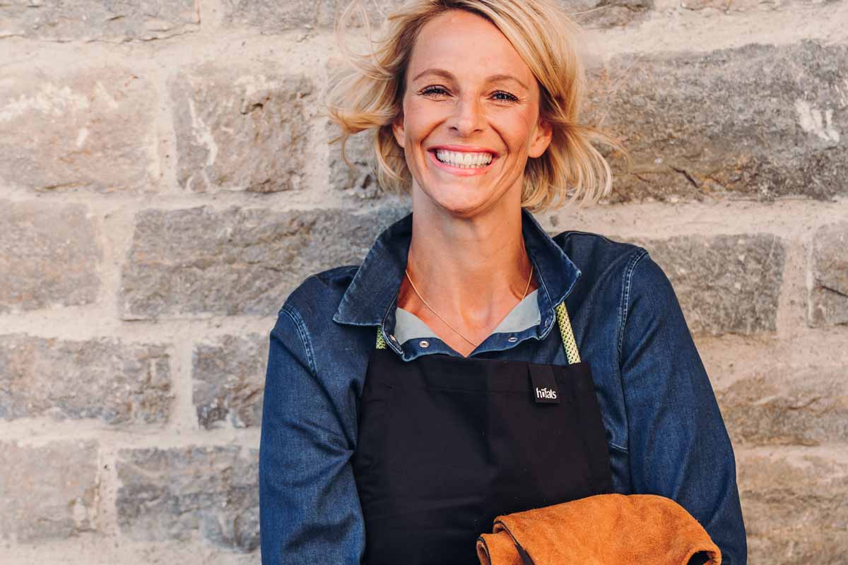 Schürze Das Foto zeigt eine Frau in einem Schürze und Schürze, die eine Tasche hält.