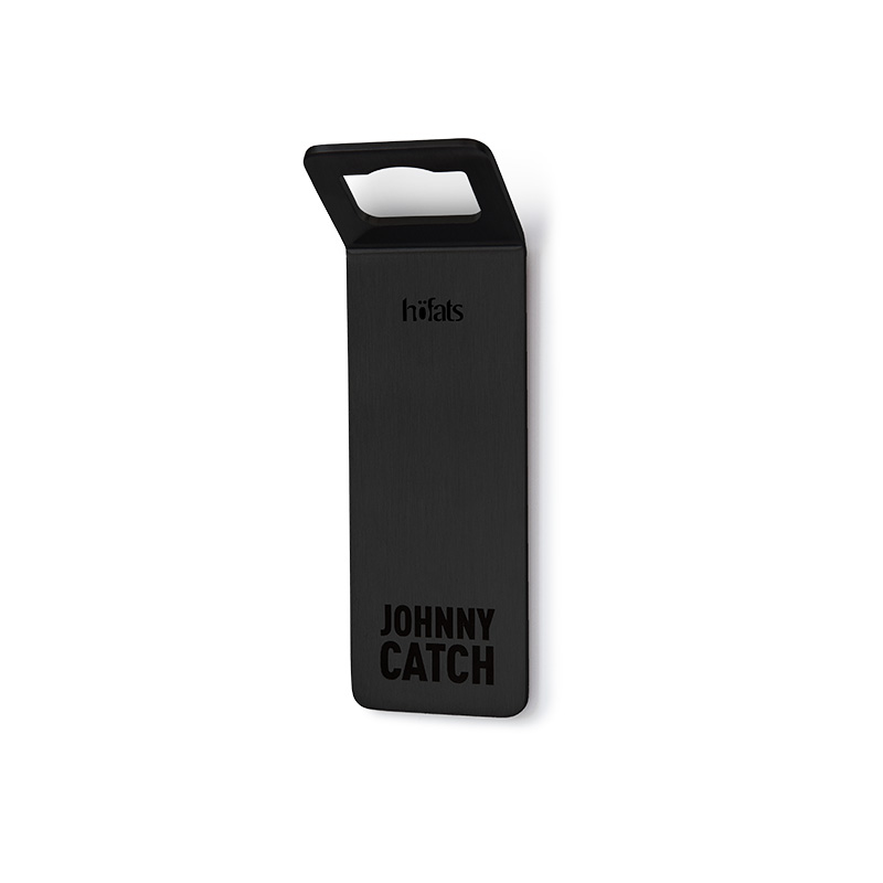 Un morceau d'acier noir avec les mots "Johnny Catch" dessus, enrichi par la présence de l'ouvre-bouteille magnétique noir 00841 Johnny Catch, qui allie design et utilité.