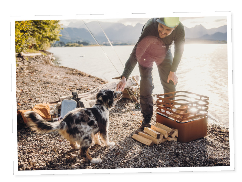 Une femme et son chien pêchent sur un lac.