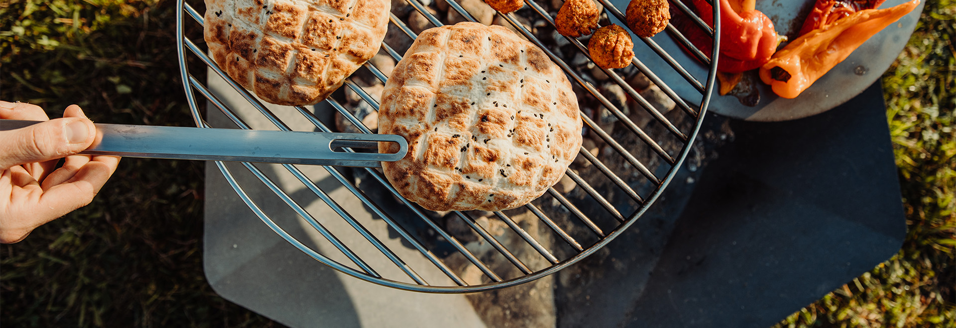 This image shows a person is holding a knife over a grill