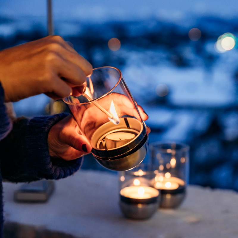 This image shows a person holding a candle in their hand, with the LOGO GRAVITY CANDLE M90 Lantern.