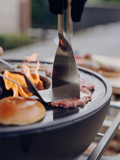 Ici, une personne Grille un hamburger sur un grill.