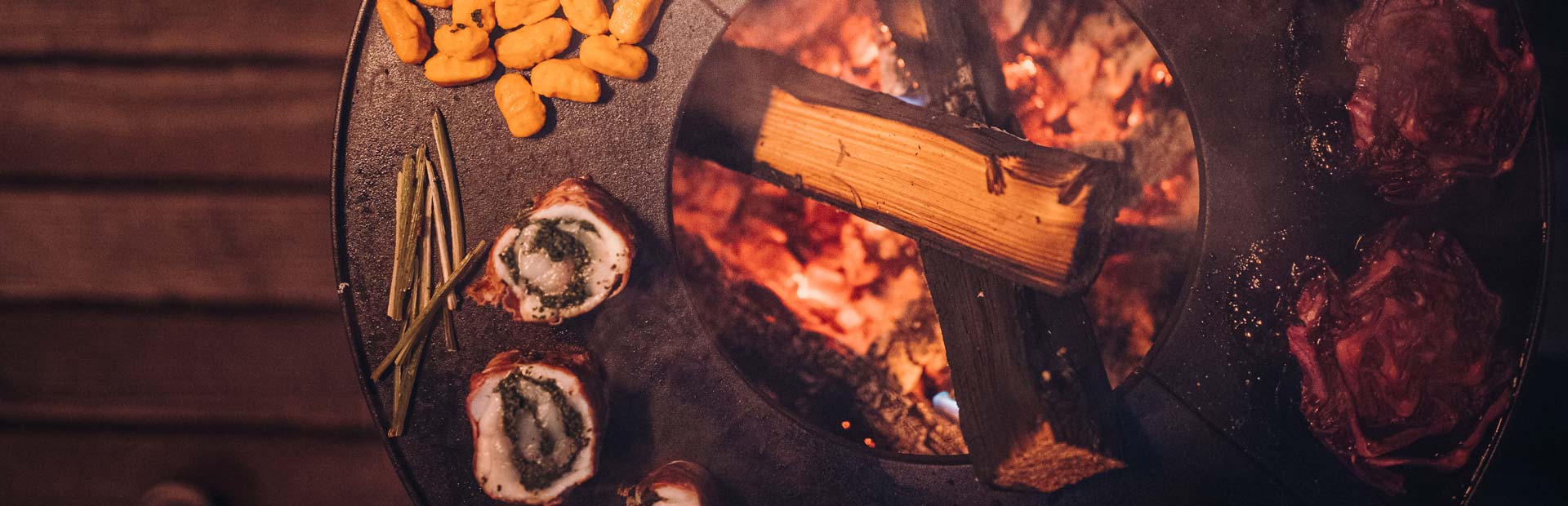 An image showing a grill with food on it, with the BOWL Fire Bowl.