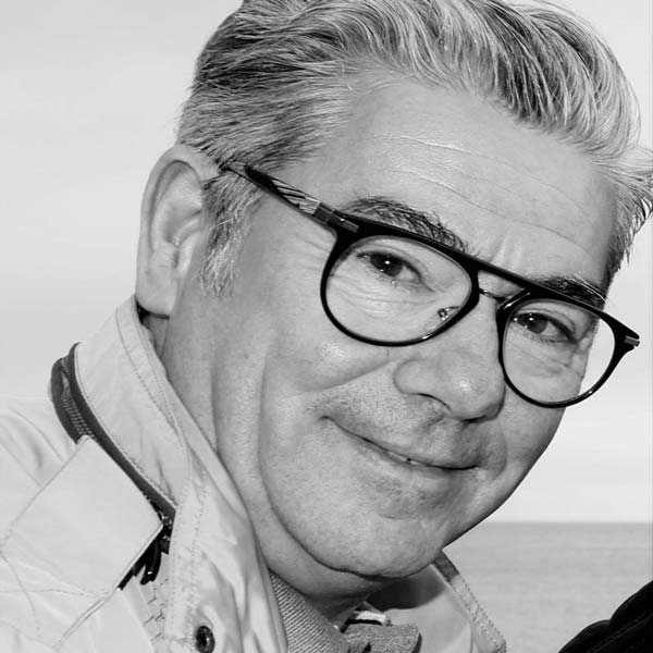 Un homme avec des lunettes et une SHIRT blanche.