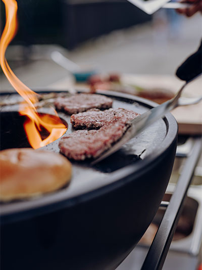 Das Foto zeigt einen Grill mit einem Hamburger darauf.
