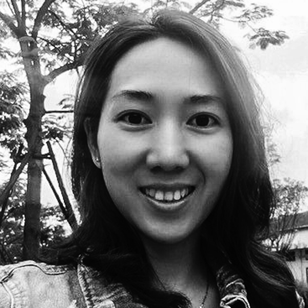 Une femme debout devant un arbre.