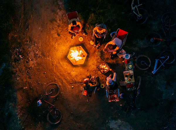 Feuer Knigge Eine Gruppe von Menschen sitzt um einen Feuergrube herum.