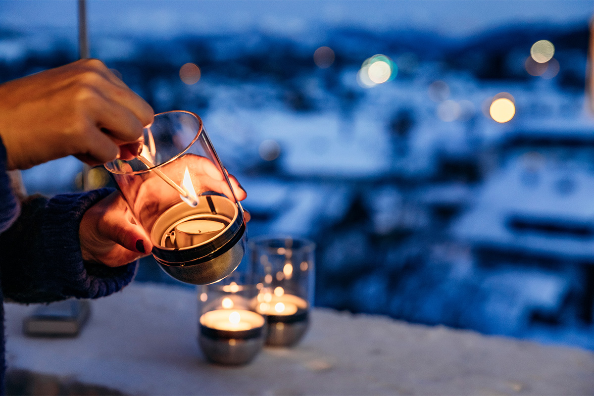 A depiction of a person holding a tea light in their hand, featuring the Gravity Candle