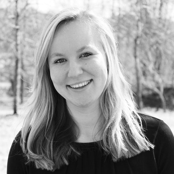 Une femme en SHIRT noire sourit à la caméra.