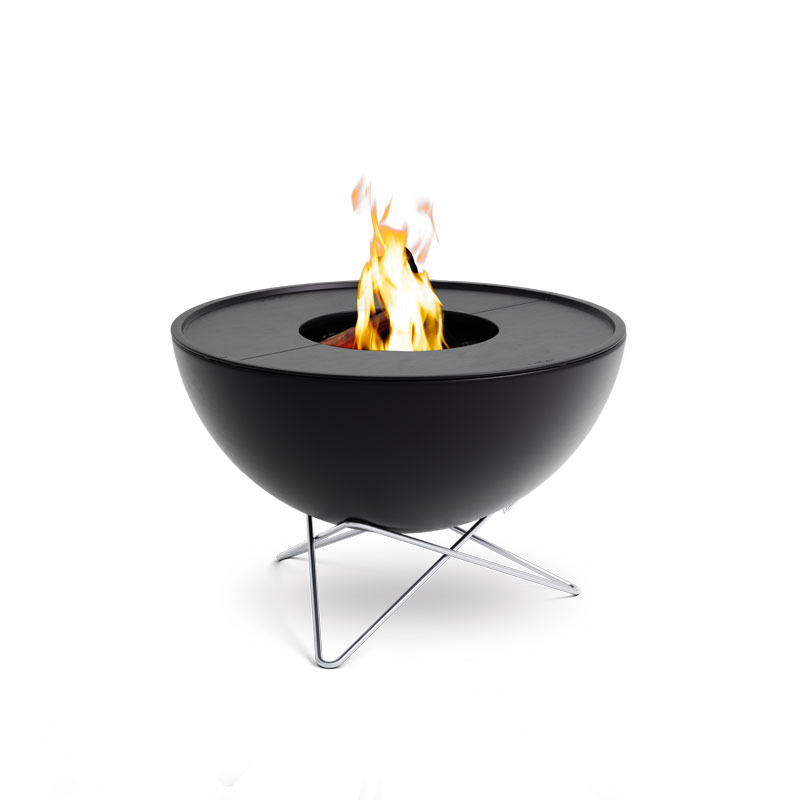 Ici est représenté un bol à feu noir avec une flamme au sommet, avec l'ensemble BBQ Plancha BOWL 70 à basse hauteur.