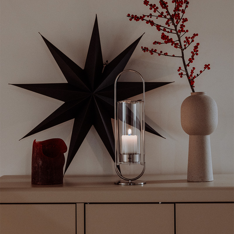 Un vase avec une bougie et une bougie en forme d'étoile complète le moment avec son design réfléchi.