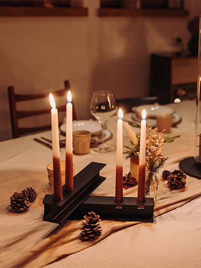 a table with a candle and a candle holder, showing the Henry Metal Candleholder Black
