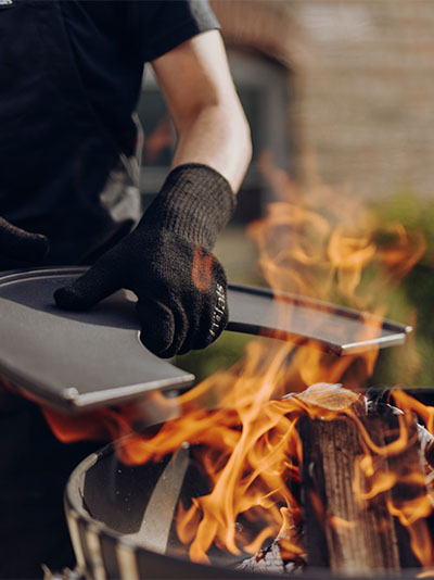 a man is cooking on a grill with flames